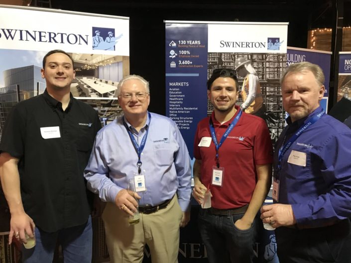 Swinerton team stands in front of signage at Dallas ASA event