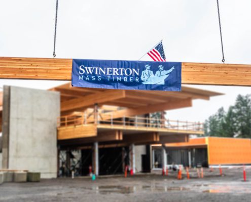 Swinerton Mass Timber banner on beam; topping out Hillsboro community center