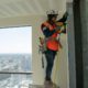 women construction hanging drywall