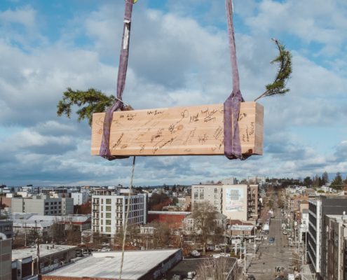 Last wood beam for heartwood, First Mass Timber Middle-Income Housing Development in U.S. being raised.